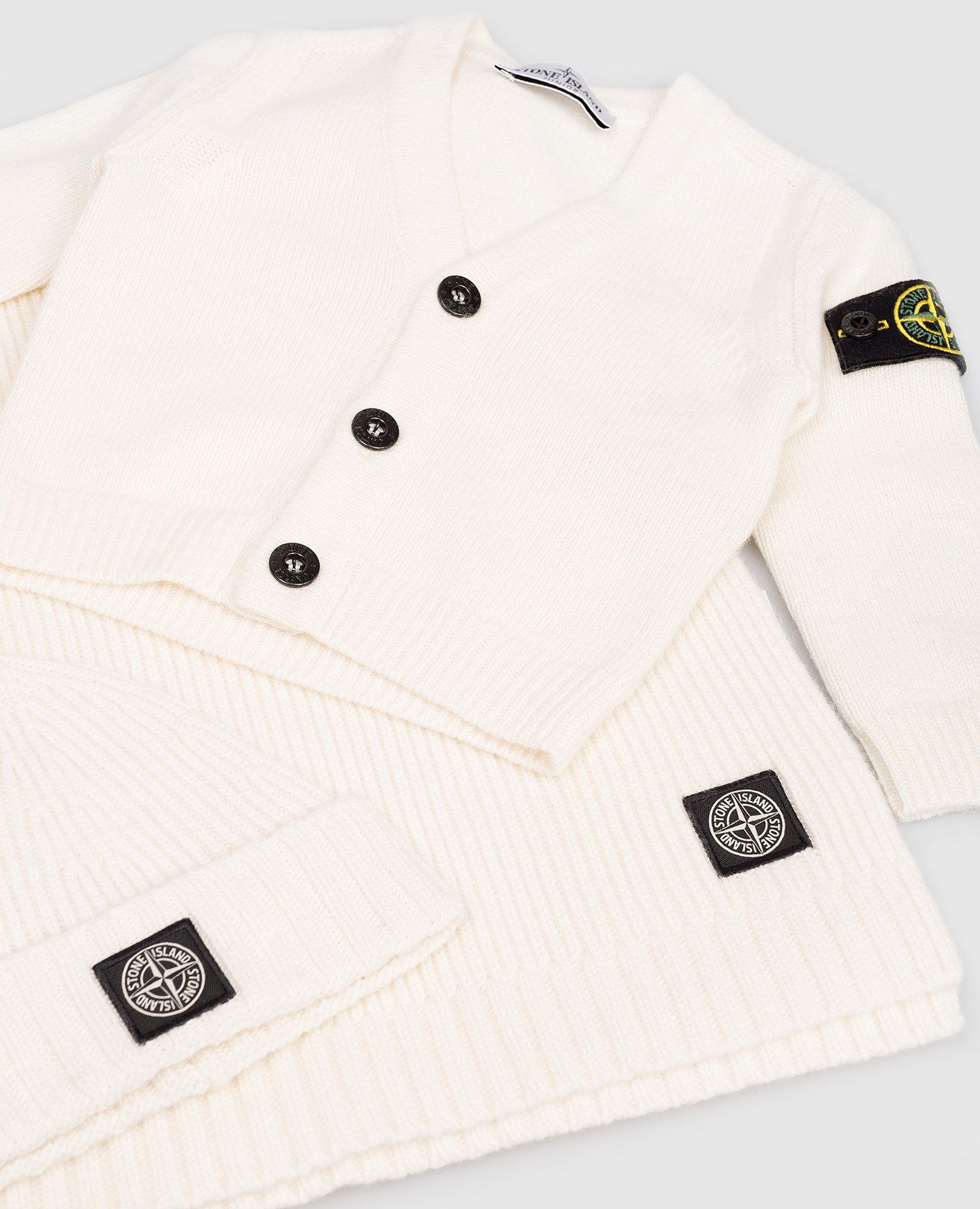 

Children's set of a white cardigan, plaid and hat with a logo Stone Island