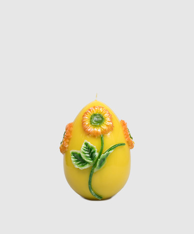 Yellow egg-shaped candle with gerbera