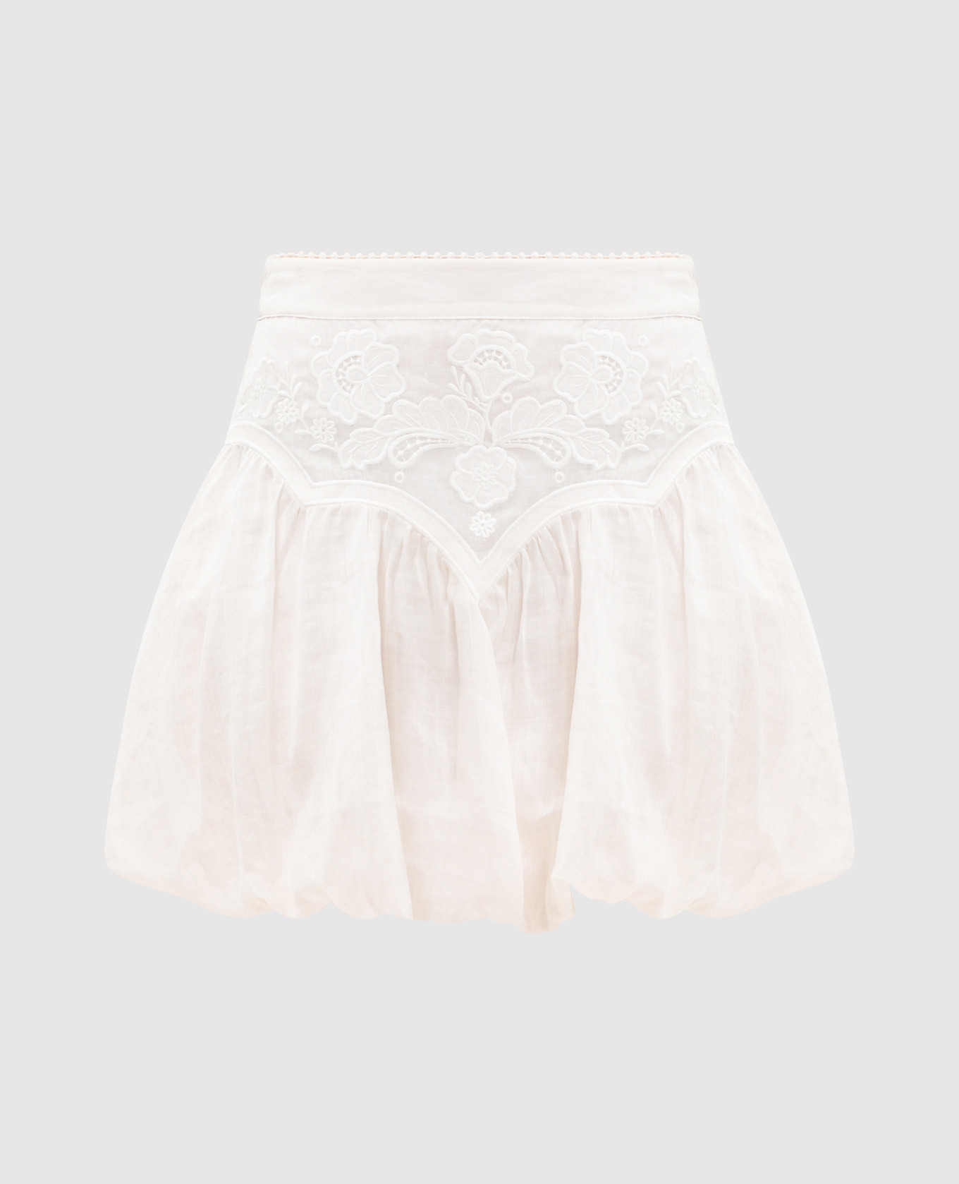 Mini-jupe blanche ornée de broderies.